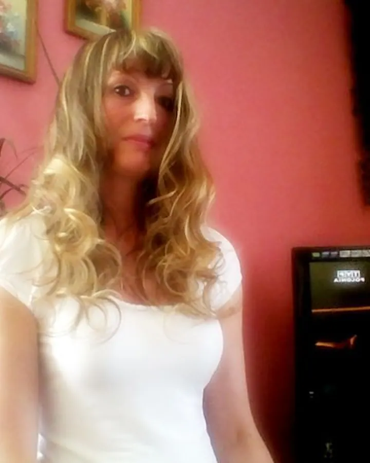 Femme en haut vert, souriante, regard baissé